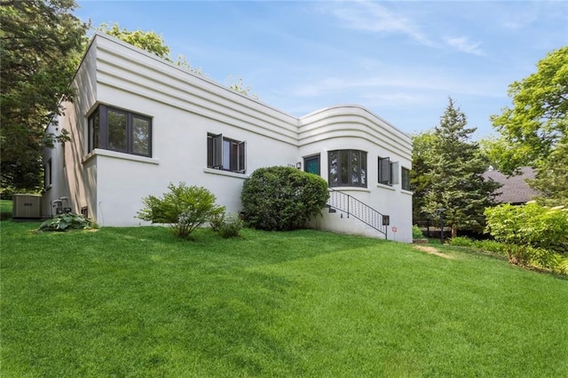5308 Foster St, Overland Park, KS 66202 - back of house with a lawn, stucco siding, and central AC unit