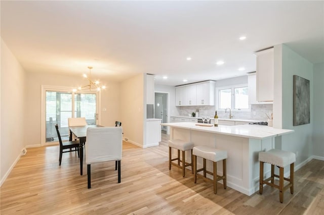 5308 Foster St, Overland Park, KS 66202 - kitchen with a kitchen bar, baseboards, tasteful backsplash, light wood finished floors, and recessed lighting
