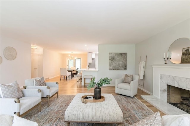 5308 Foster St, Overland Park, KS 66202 - living area with a premium fireplace, light wood-style floors, a chandelier, and baseboards