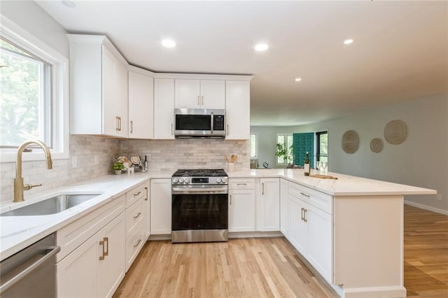 5308 Foster St, Overland Park, KS 66202 - kitchen featuring stainless steel appliances, a sink, a peninsula, backsplash, and recessed lighting