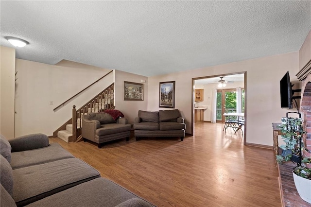 446 Hithergreen Dr, Lansing, KS 66043 - living area featuring a textured ceiling, light wood-type flooring, stairway, and ceiling fan