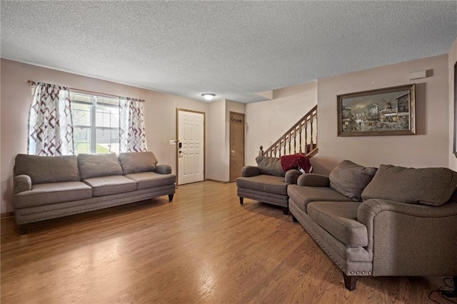 446 Hithergreen Dr, Lansing, KS 66043 - living room featuring stairway, a textured ceiling, and light wood-style flooring