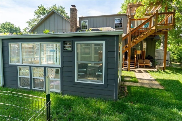 1504 SW 9th St, Lees Summit, MO 64081 - back of house with board and batten siding, stairs, a wooden deck, a storage unit, and a chimney