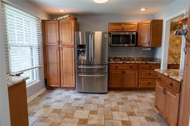 1504 SW 9th St, Lees Summit, MO 64081 - kitchen featuring stainless steel appliances, brown cabinets, light stone counters, stone finish flooring, and recessed lighting