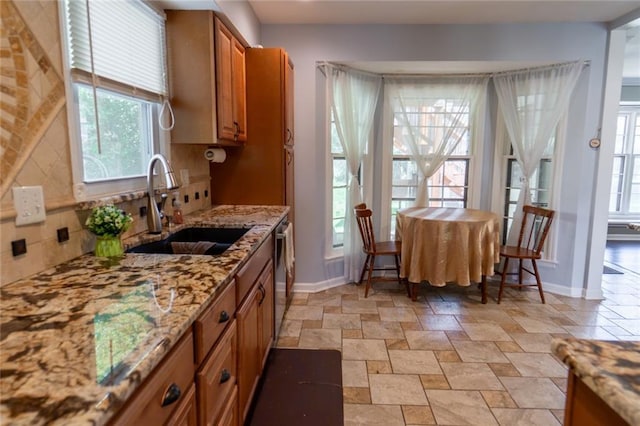 1504 SW 9th St, Lees Summit, MO 64081 - kitchen featuring brown cabinets, stone finish floors, light stone counters, dishwasher, and tasteful backsplash