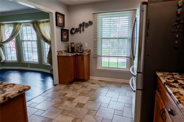 1504 SW 9th St, Lees Summit, MO 64081 - kitchen with freestanding refrigerator, brown cabinets, stone tile flooring, crown molding, and light stone counters
