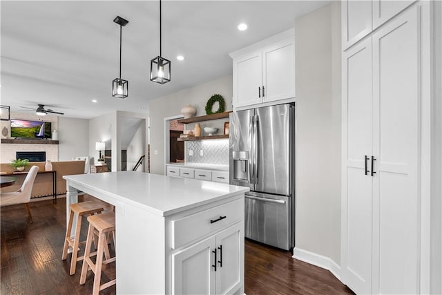 19714 W 197th Ct, Spring Hill, KS 66083 - kitchen featuring stainless steel refrigerator with ice dispenser, dark wood finished floors, a fireplace, ceiling fan, and light countertops