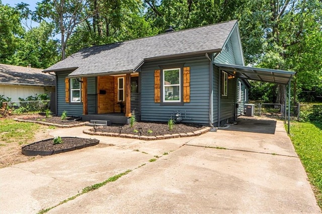 1115 S Leslie St, Independence, MO 64050 - view of front of property featuring concrete driveway, covered porch, a shingled roof, and an attached carport