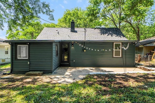 1115 S Leslie St, Independence, MO 64050 - rear view of property featuring a chimney, a patio, and roof with shingles