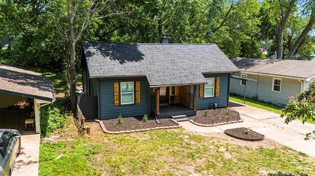 1115 S Leslie St, Independence, MO 64050 - view of front of house with a porch, driveway, a shingled roof, and a front yard