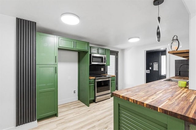 1115 S Leslie St, Independence, MO 64050 - kitchen featuring green cabinetry, appliances with stainless steel finishes, butcher block countertops, and light wood-style flooring
