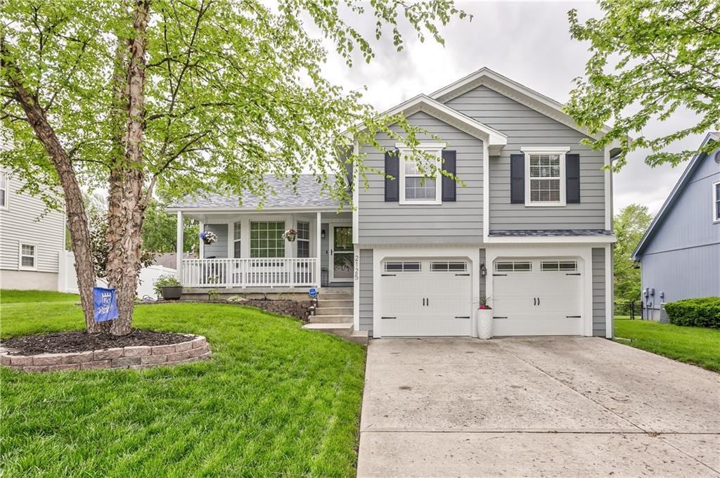 2125 NE Chipman Rd, Lees Summit, MO 64086 - tri-level home featuring covered porch, a front yard, an attached garage, and driveway