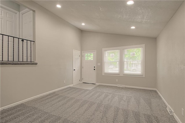 11300 Greenwood Rd, Kansas City, MO 64134 - foyer entrance featuring vaulted ceiling, recessed lighting, carpet floors, baseboards, and a textured ceiling