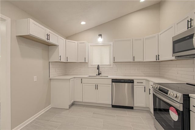 11300 Greenwood Rd, Kansas City, MO 64134 - kitchen with stainless steel appliances, a sink, lofted ceiling, tasteful backsplash, and white cabinetry