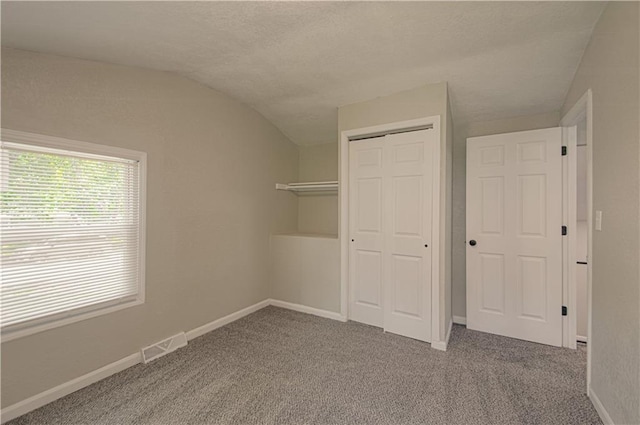 11300 Greenwood Rd, Kansas City, MO 64134 - unfurnished bedroom with vaulted ceiling, carpet flooring, a closet, baseboards, and a textured ceiling
