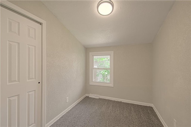 11300 Greenwood Rd, Kansas City, MO 64134 - unfurnished room with dark carpet, a textured wall, a textured ceiling, and baseboards