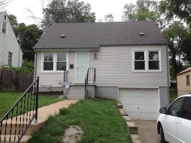 7429 Walrond Ave, Kansas City, MO 64132 - view of front facade featuring a garage, roof with shingles, and concrete driveway