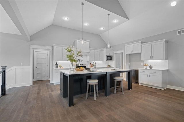 19433 W 114th Ter, Olathe, KS 66061 - kitchen with appliances with stainless steel finishes, white cabinetry, a center island with sink, light countertops, and recessed lighting