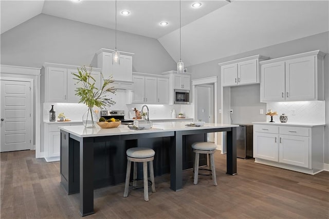 19433 W 114th Ter, Olathe, KS 66061 - kitchen with appliances with stainless steel finishes, white cabinets, decorative backsplash, an island with sink, and high vaulted ceiling