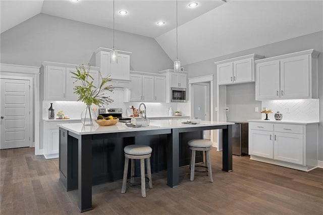 19433 W 114th Ter, Olathe, KS 66061 - kitchen with appliances with stainless steel finishes, white cabinets, tasteful backsplash, a center island with sink, and high vaulted ceiling