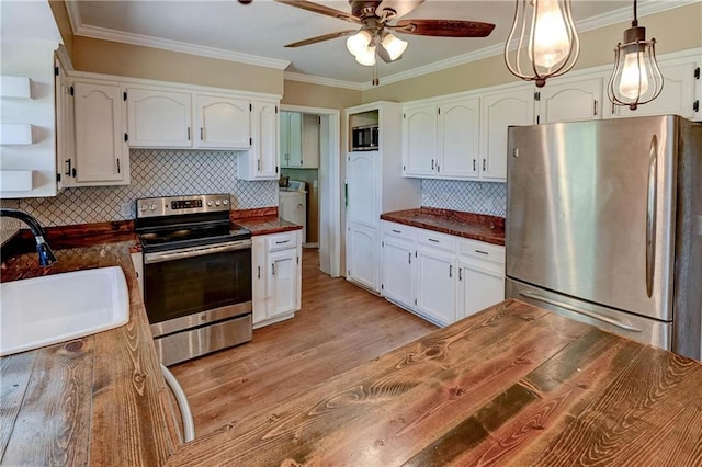 739 SW 700th Rd, Holden, MO 64040 - kitchen with stainless steel appliances, a sink, ceiling fan, white cabinetry, and crown molding