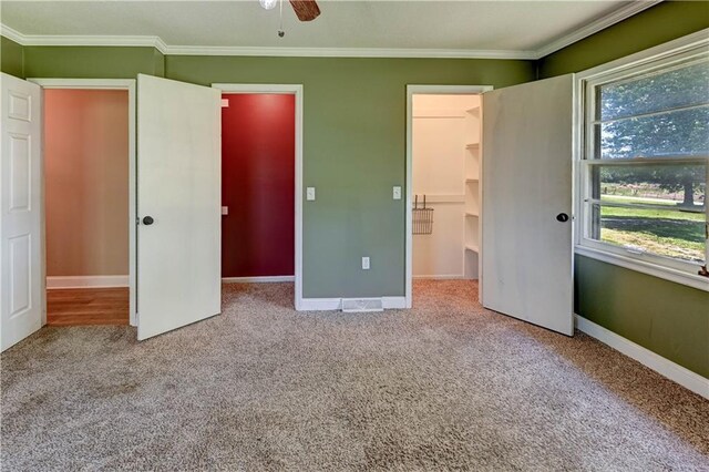 739 SW 700th Rd, Holden, MO 64040 - unfurnished bedroom with a walk in closet, carpet floors, crown molding, baseboards, and a closet