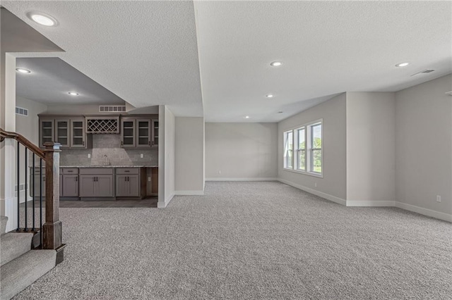 19477 W 114th Ter, Olathe, KS 66061 - unfurnished living room featuring a textured ceiling, light carpet, stairs, and recessed lighting