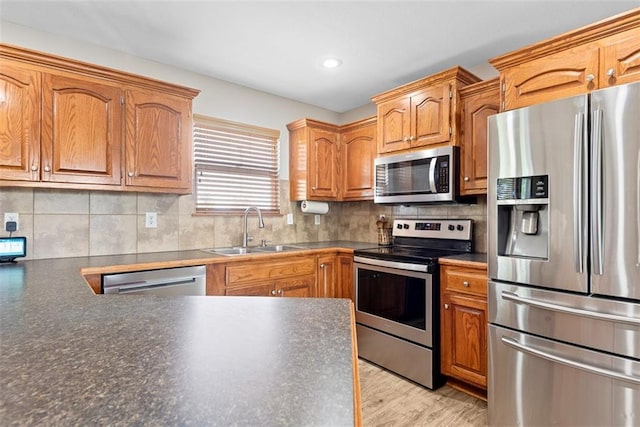 601 W 3rd Ter, Wellsville, KS 66092 - kitchen featuring stainless steel appliances, a sink, dark countertops, tasteful backsplash, and recessed lighting