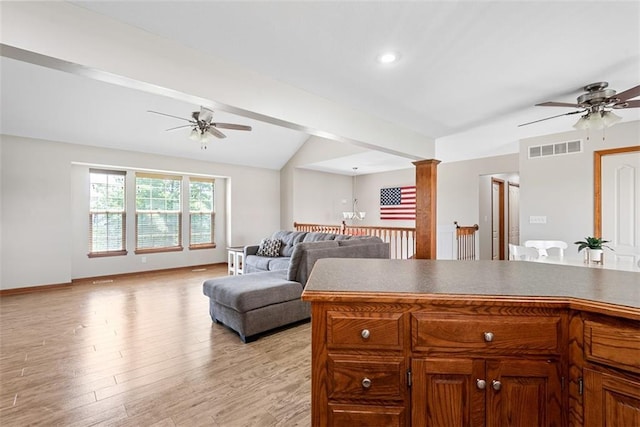 601 W 3rd Ter, Wellsville, KS 66092 - kitchen featuring ceiling fan, vaulted ceiling, light wood finished floors, brown cabinetry, and open floor plan