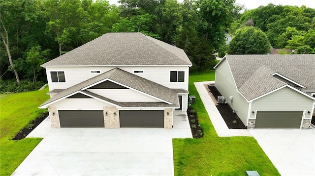 801 Highland Dr, Edwardsville, KS 66111 - view of front facade featuring concrete driveway, a front yard, and roof with shingles