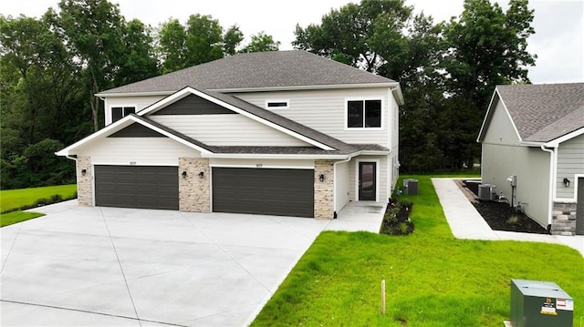 801 Highland Dr, Edwardsville, KS 66111 - view of front of house with driveway, a front lawn, central AC unit, and an attached garage