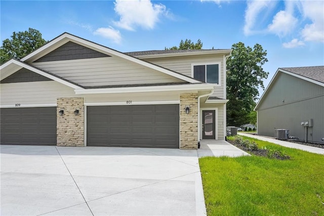 801 Highland Dr, Edwardsville, KS 66111 - view of front facade featuring a garage, stone siding, concrete driveway, and a front yard