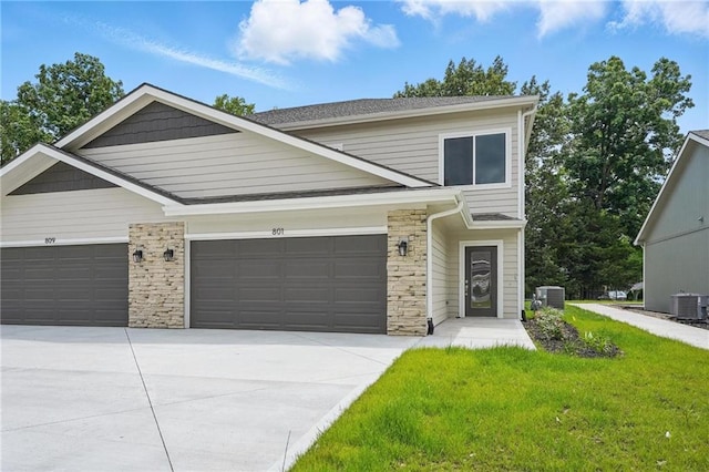 801 Highland Dr, Edwardsville, KS 66111 - view of front facade featuring an attached garage, central AC, concrete driveway, and a front yard