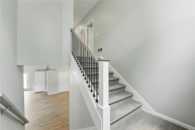 801 Highland Dr, Edwardsville, KS 66111 - stairs featuring a towering ceiling, ceiling fan, baseboards, and wood finished floors