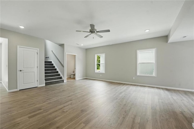 801 Highland Dr, Edwardsville, KS 66111 - unfurnished living room with stairs, a ceiling fan, wood finished floors, baseboards, and recessed lighting