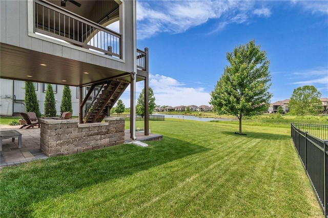 9812 Saddletop St, Lenexa, KS 66227 - view of yard featuring stairway, a patio, and a deck with water view