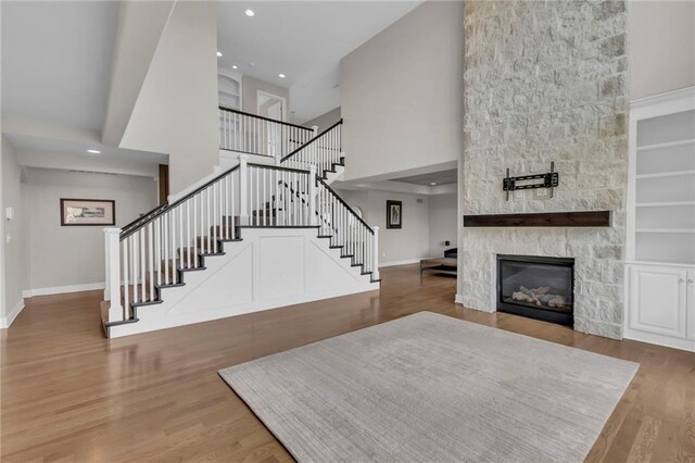 9812 Saddletop St, Lenexa, KS 66227 - living area with stairway, a towering ceiling, wood finished floors, a stone fireplace, and recessed lighting