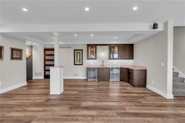 9812 Saddletop St, Lenexa, KS 66227 - indoor wet bar with beverage cooler, stairs, dark wood-type flooring, and recessed lighting