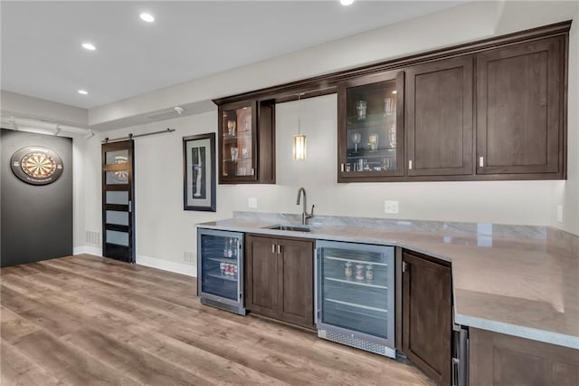 9812 Saddletop St, Lenexa, KS 66227 - indoor wet bar with beverage cooler, a barn door, light wood finished floors, and recessed lighting