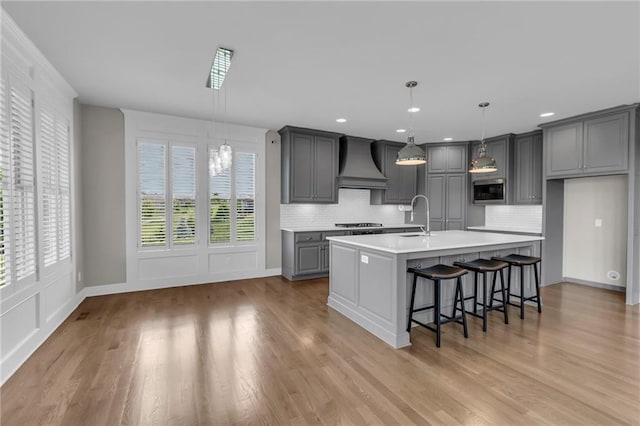 9812 Saddletop St, Lenexa, KS 66227 - kitchen with custom exhaust hood, gray cabinets, light countertops, tasteful backsplash, and recessed lighting