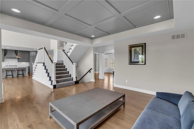 9812 Saddletop St, Lenexa, KS 66227 - living area featuring decorative columns, coffered ceiling, stairway, recessed lighting, and wood finished floors