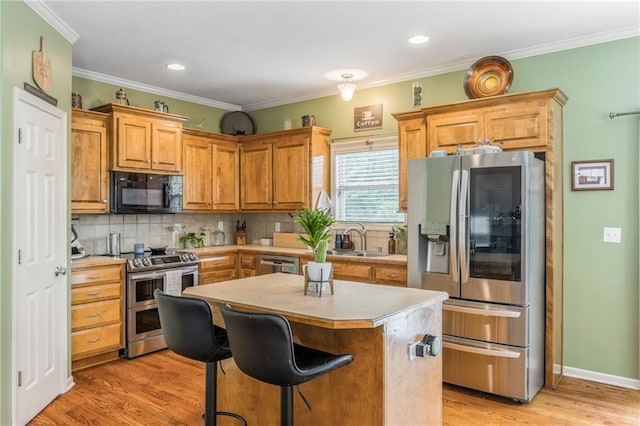 2420 SW Golden Eagle Rd, Lees Summit, MO 64082 - kitchen featuring appliances with stainless steel finishes, a sink, light countertops, backsplash, and a center island