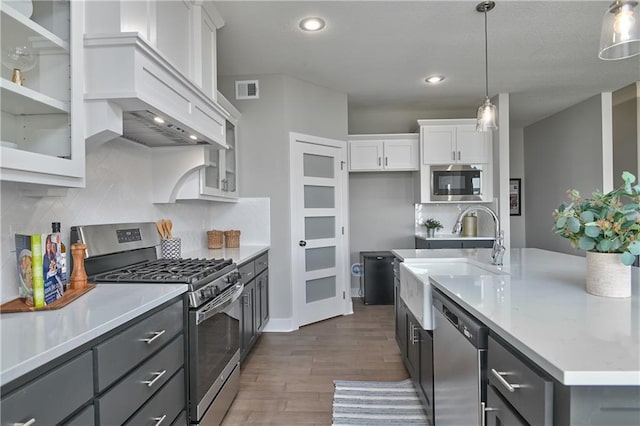 5858 Mccormick Dr, Shawnee, KS 66226 - kitchen with stainless steel appliances, a sink, dark wood finished floors, white cabinetry, and light countertops