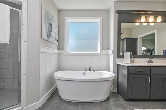 5858 Mccormick Dr, Shawnee, KS 66226 - full bath featuring a wainscoted wall, a shower stall, a freestanding tub, vanity, and tile patterned flooring