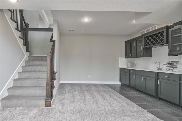 5858 Mccormick Dr, Shawnee, KS 66226 - kitchen with light countertops, a sink, glass insert cabinets, backsplash, and baseboards