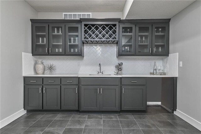 5858 Mccormick Dr, Shawnee, KS 66226 - indoor wet bar featuring backsplash, baseboards, and dark tile patterned floors