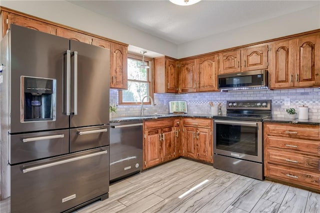 15215 Edgerton Rd, Gardner, KS 66030 - kitchen featuring stainless steel appliances, brown cabinets, decorative backsplash, and a sink