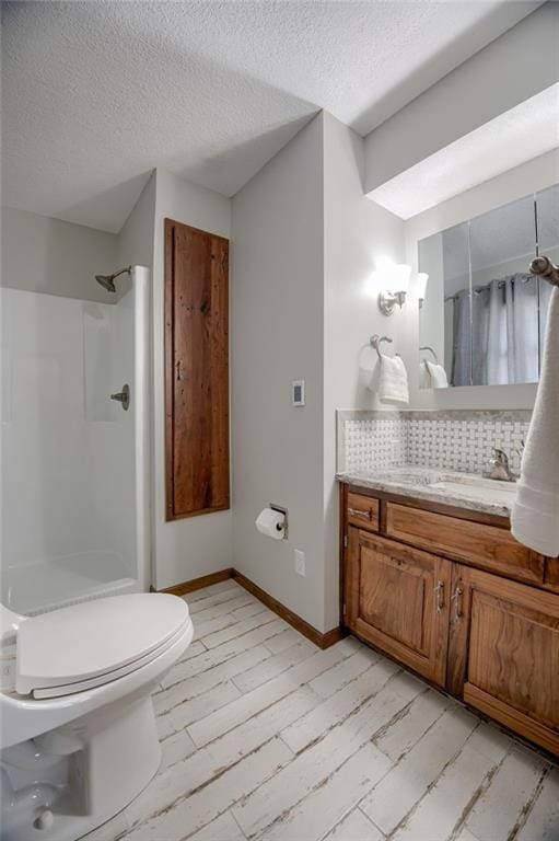 15215 Edgerton Rd, Gardner, KS 66030 - bathroom with vanity, a shower, a textured ceiling, toilet, and tasteful backsplash