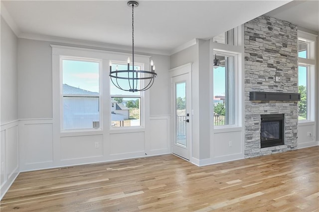 6031 Apache St, Shawnee, KS 66226 - unfurnished dining area with light wood-style floors, a chandelier, crown molding, a decorative wall, and wainscoting
