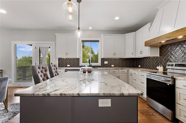 4820 NE 90th Ter, Kansas City, MO 64156 - kitchen with stainless steel electric range, a kitchen island, white cabinetry, premium range hood, and recessed lighting